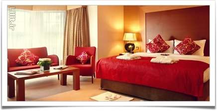 اتاق‌خواب عشاق با استفاده مبلمان قرمز مخملی و آباژور