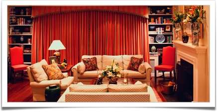 اتاق نشیمن زمستانی گرم با پرده‌های قرمز و آباژور اروپایی
